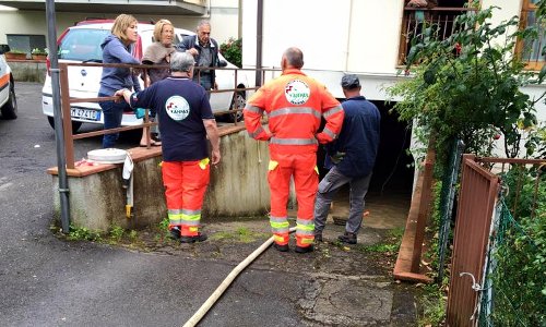 Volontari e cittadini durante òp svuotamento di un garage allagato