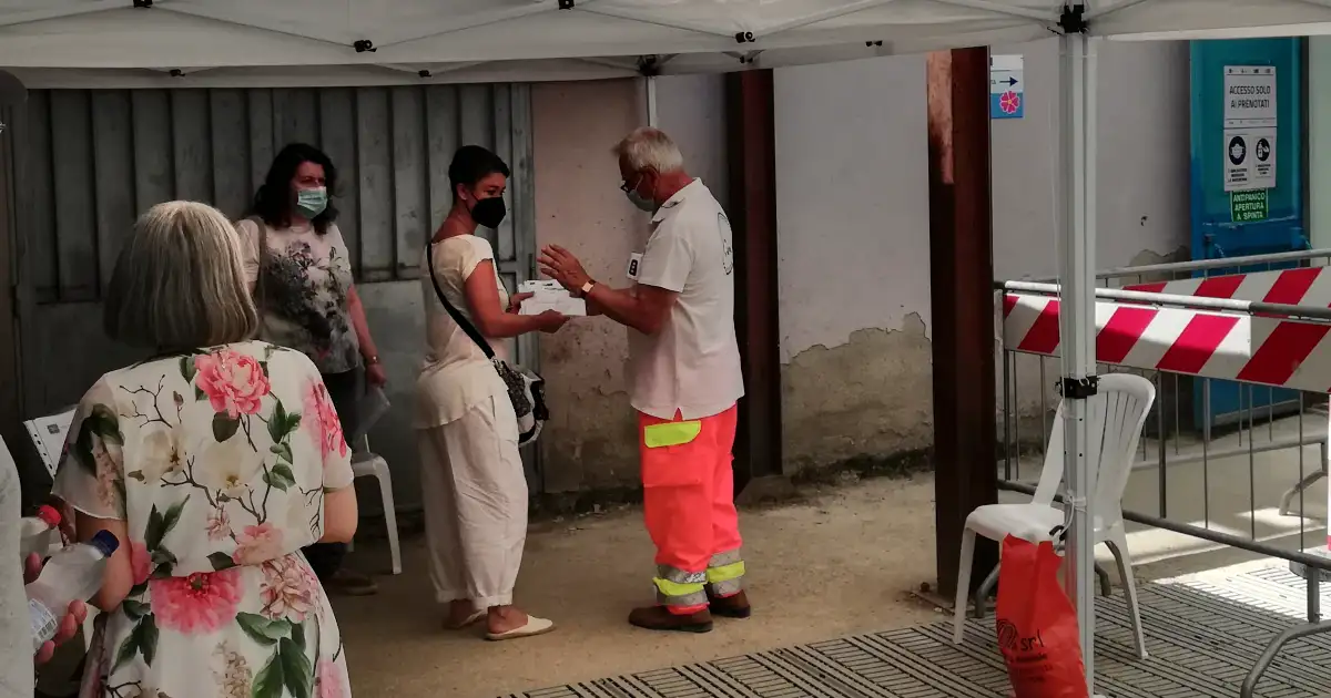 Volontario controlla documenti all'ingresso di un centro vaccinale