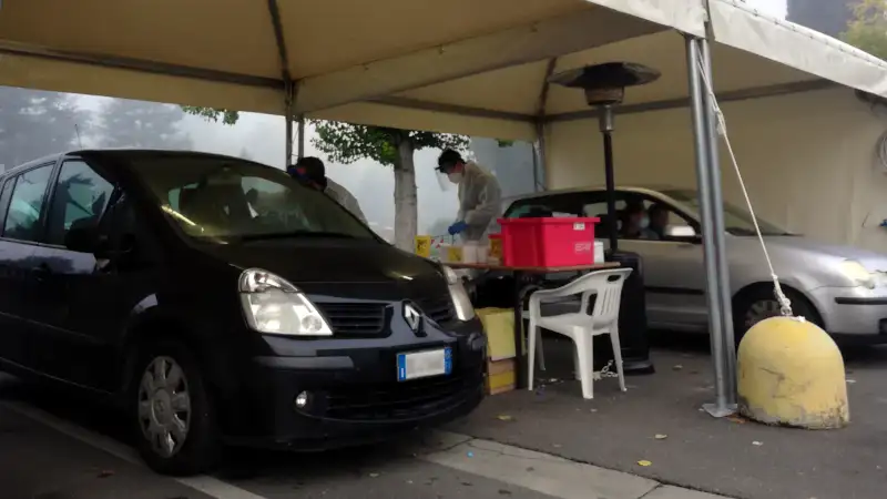 professionisti effettuano un tampone in un drive through covid