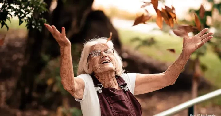 Signora anziana giova con le foglie in autunno foto di Edu Carvalho