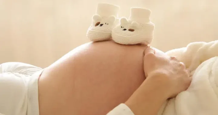 scarpine da neonato sulla pancia di mamma incinta
