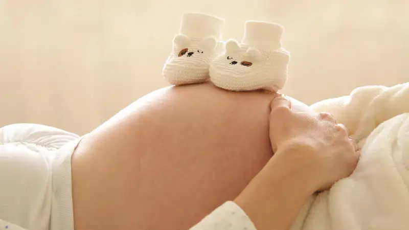 scarpine da neonato sulla pancia di mamma incinta